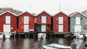 Charming red wooden houses line the waterfront in Smögen, Sweden, reflecting traditional Scandinavian architecture.